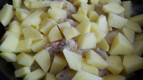 картофель с куриными крылышками и баклажанами на сковороде