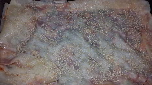 лаваш, запеченный с оливковой пастой, томатным соусом, зеленью и кунжутом