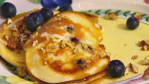 банановые оладьи с кленовым сиропом, голубикой и орехами пекан